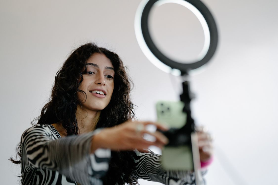 A creator setting up her phone and ring light